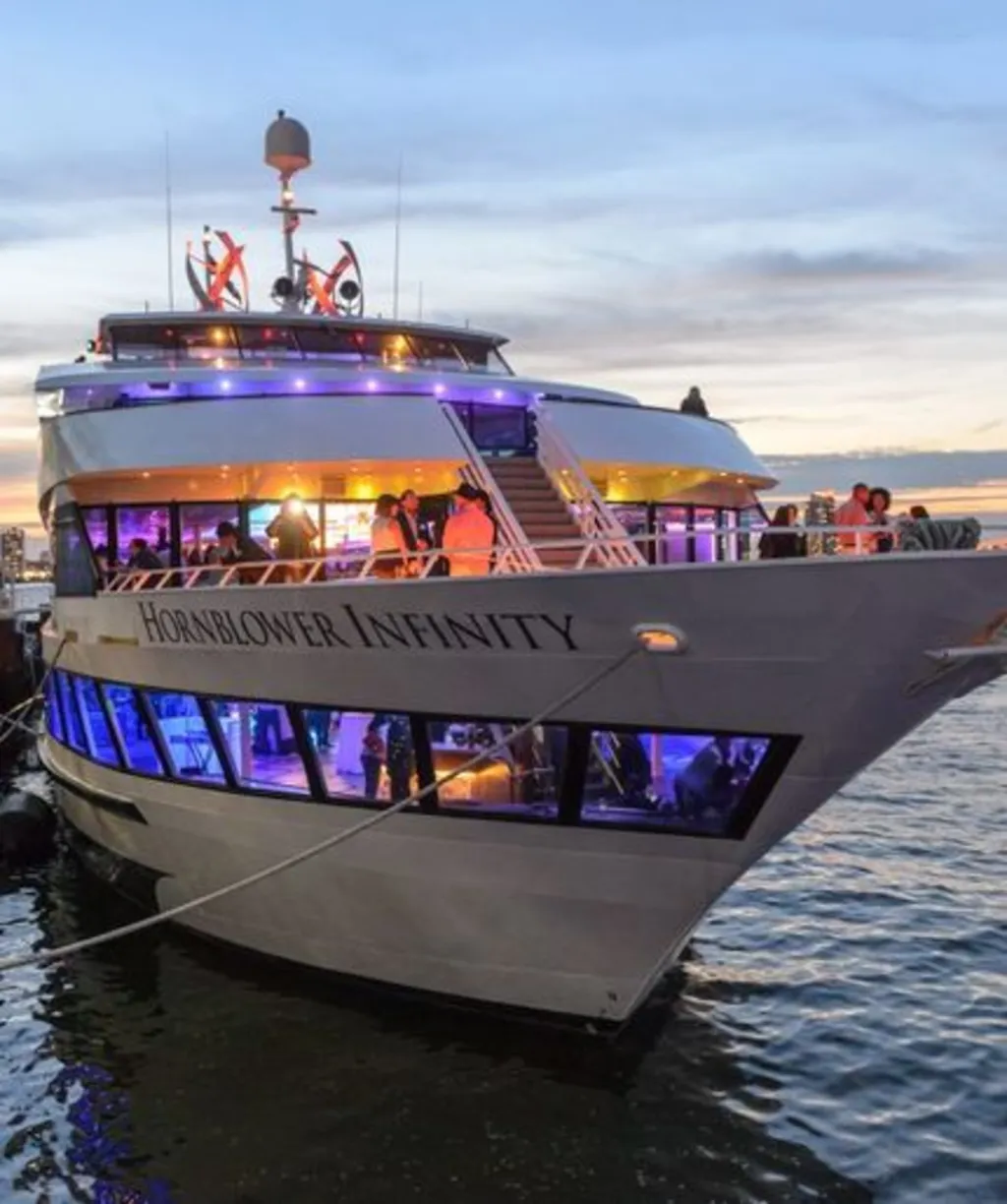 a close up of a boat with peole on the deck and different colored lighting