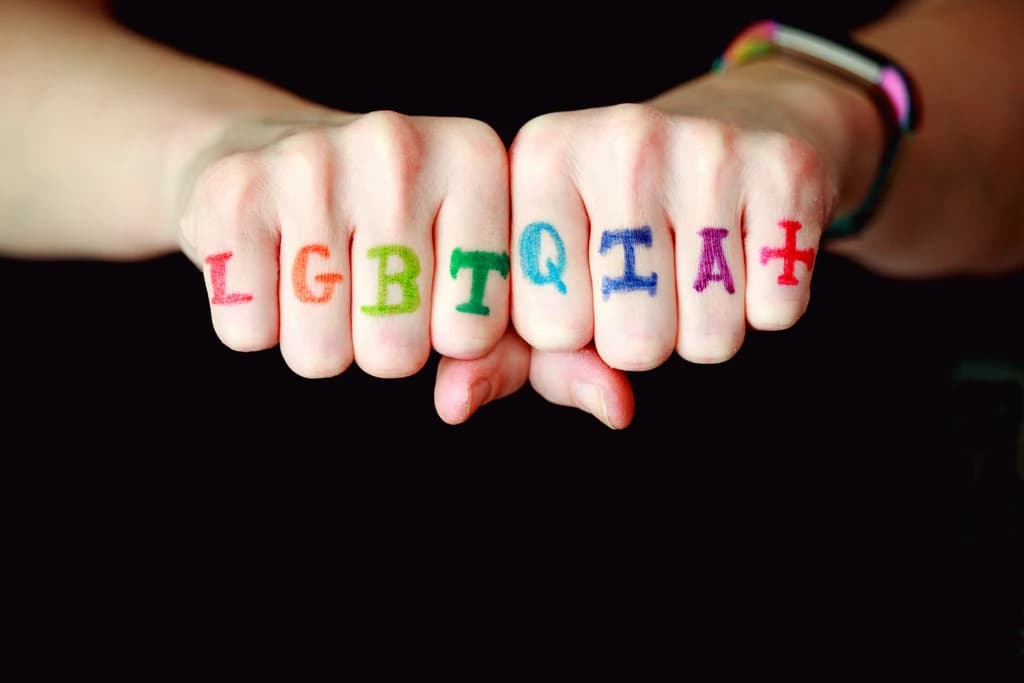 someone with lgbtqia+ painted on their fingers