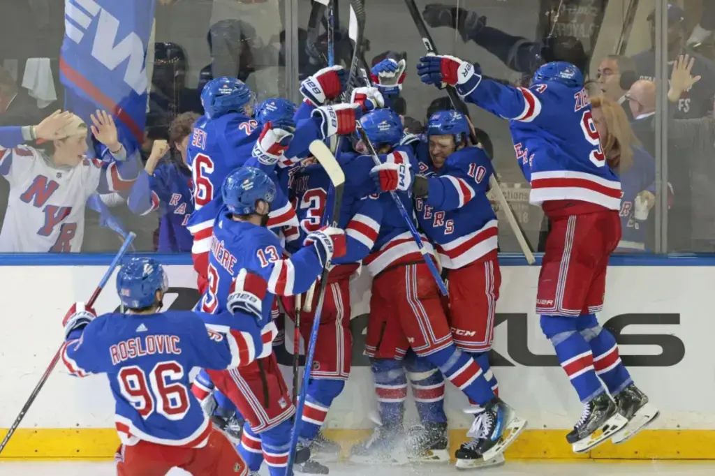 Excited fans watching a hockey game at Madison Square Garden, focusing on the New York Rangers.