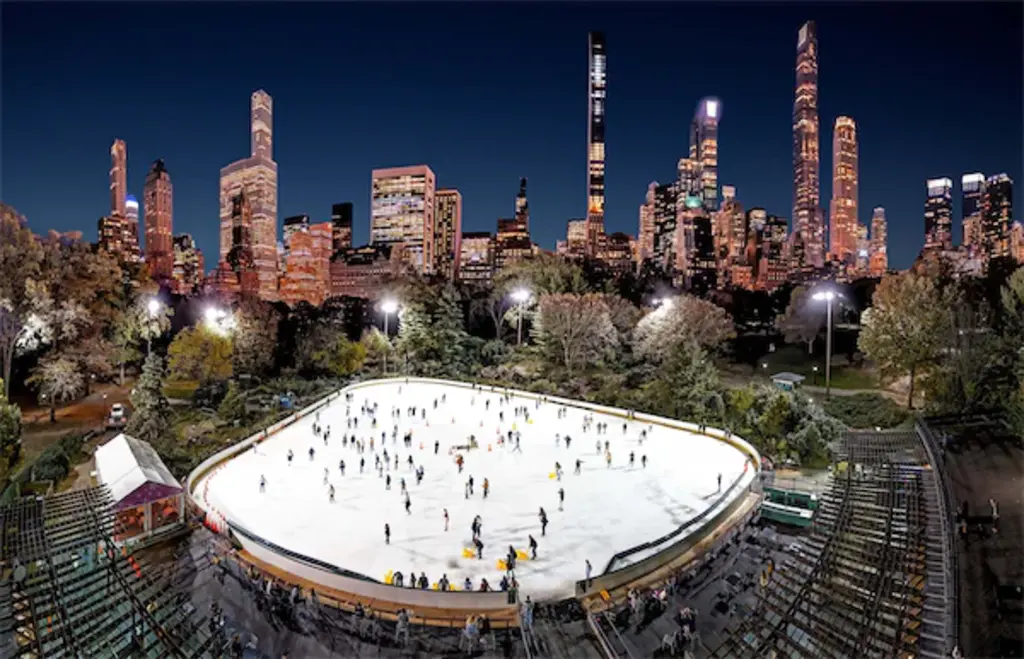 an arial view of people ice skating at a rink in central park with building in the background