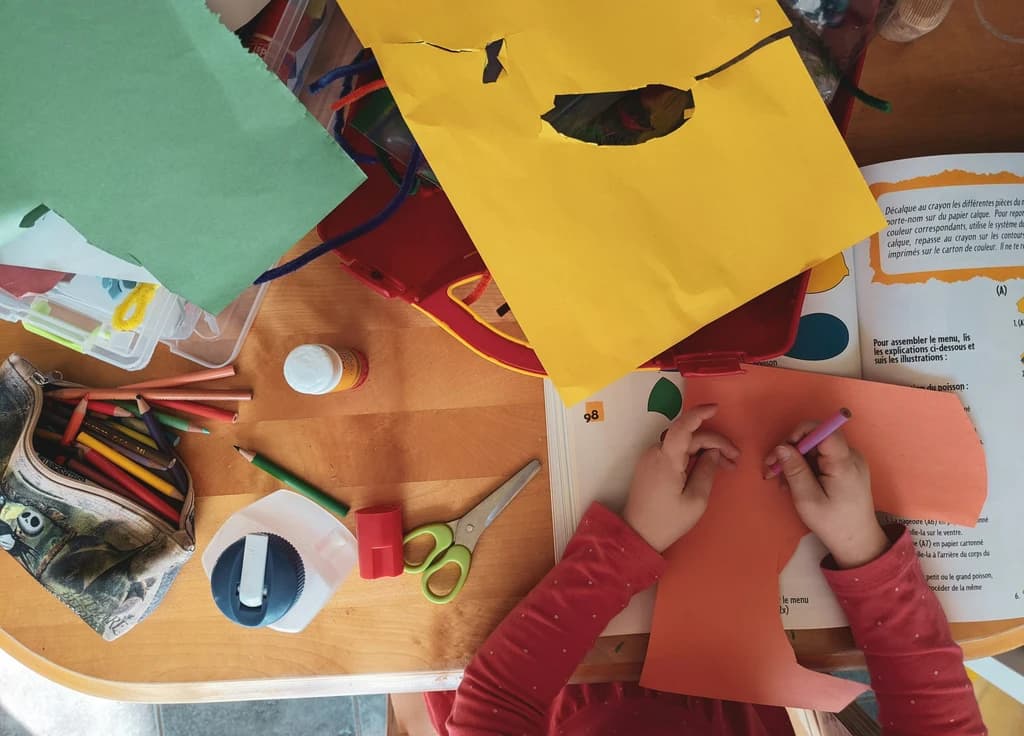 kids at a table with paper and paint in front of them