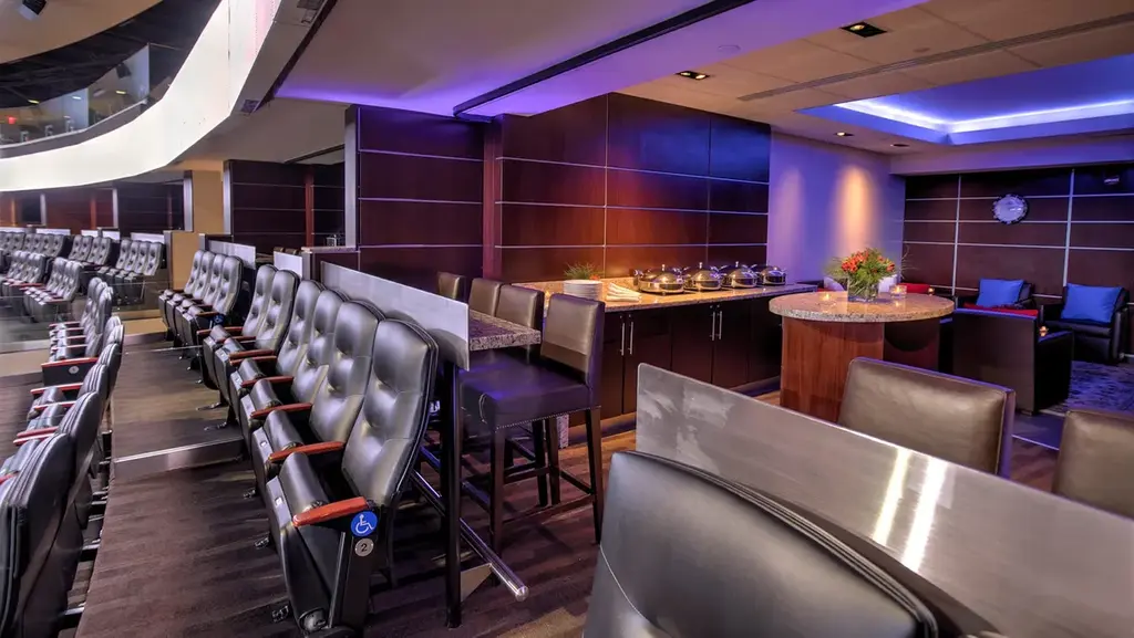 Elegant suite at Madison Square Garden featuring leather seats, a dining area, and upscale interior decor.