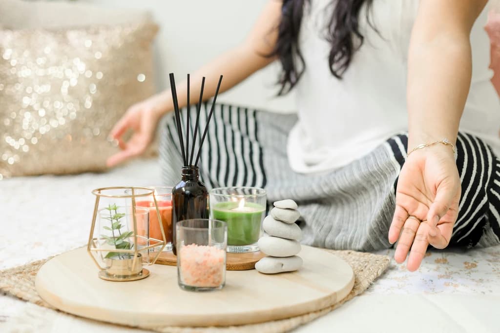 a close up of a person meditating with candles infront of them