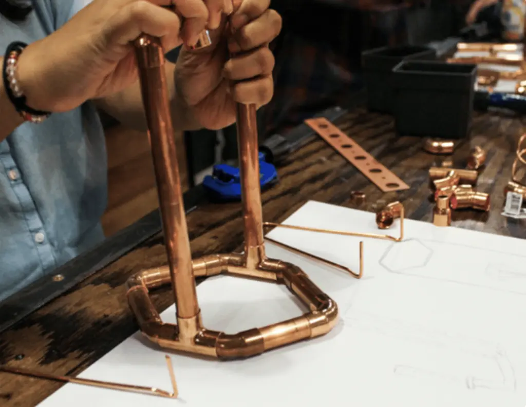 a person putting copper pipe together
