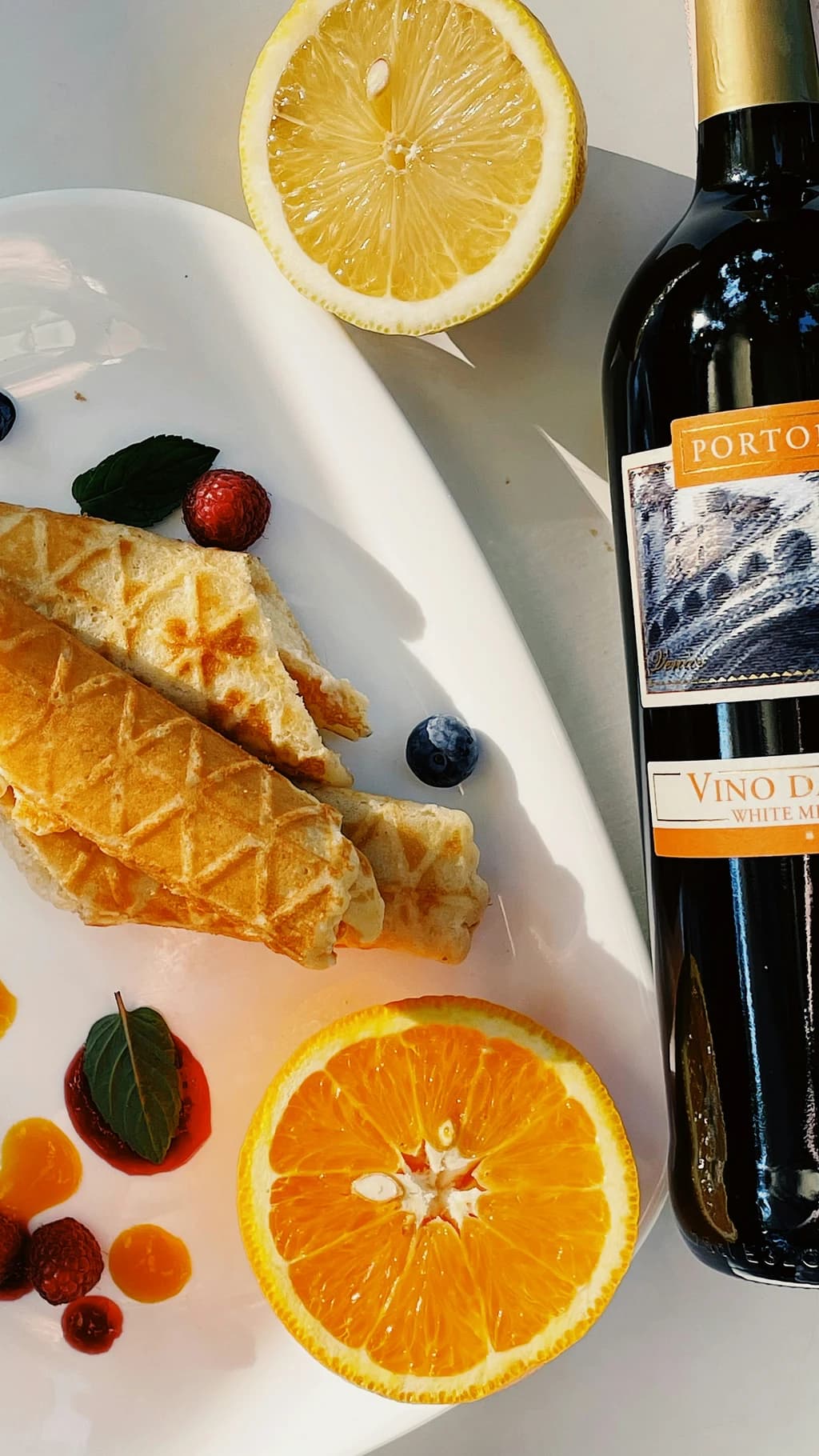 a bottle of wine with oranges and food around it