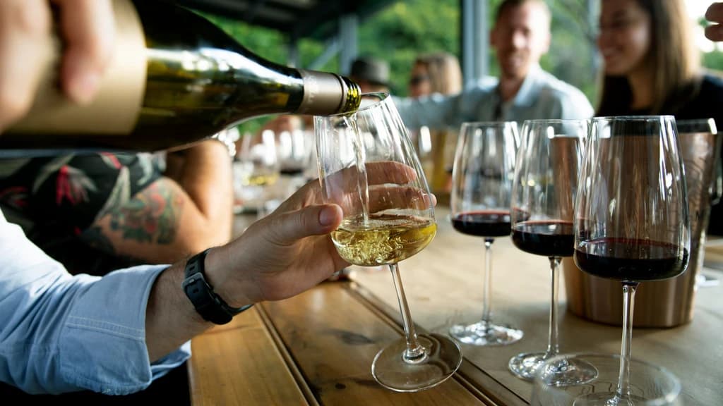 someone pouring a glass of line at a bar