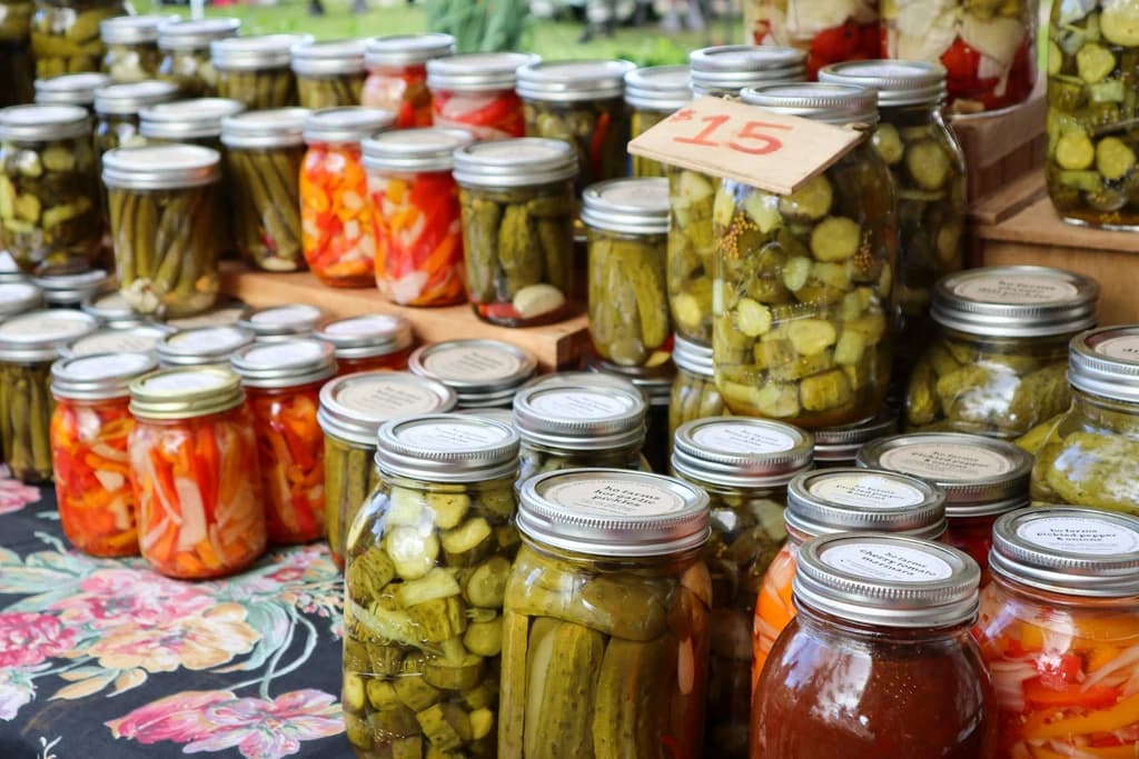 rows of jars of different homemade pickled vegetables