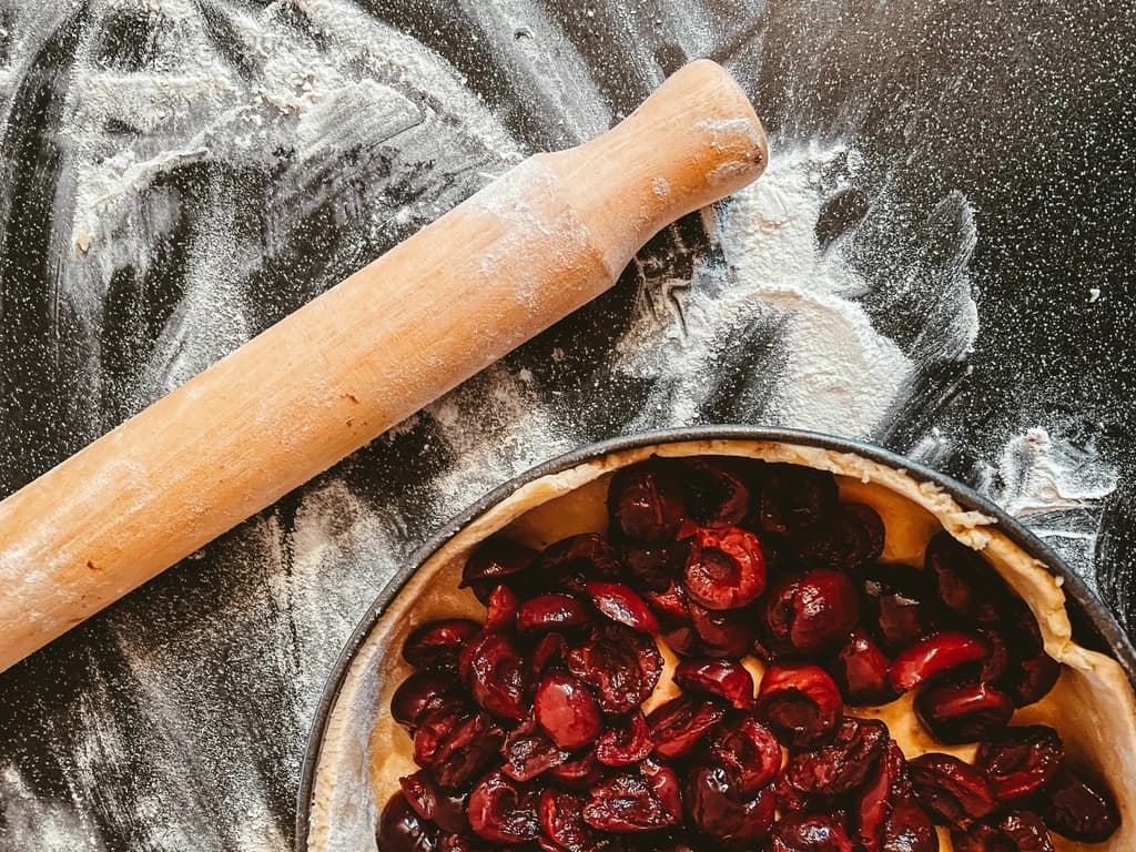 a pie with filling and a rolling pin next to it