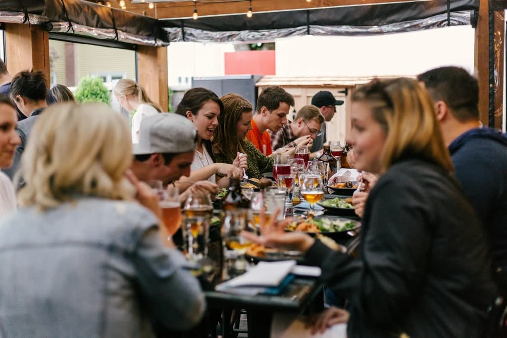 a group of people seated at a table enjoying food and drinks