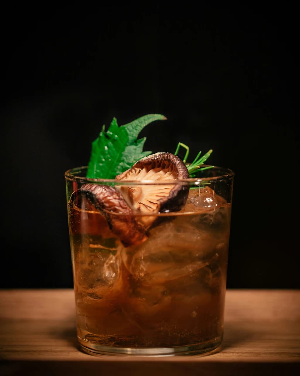 a mixed drink with ice and garnish