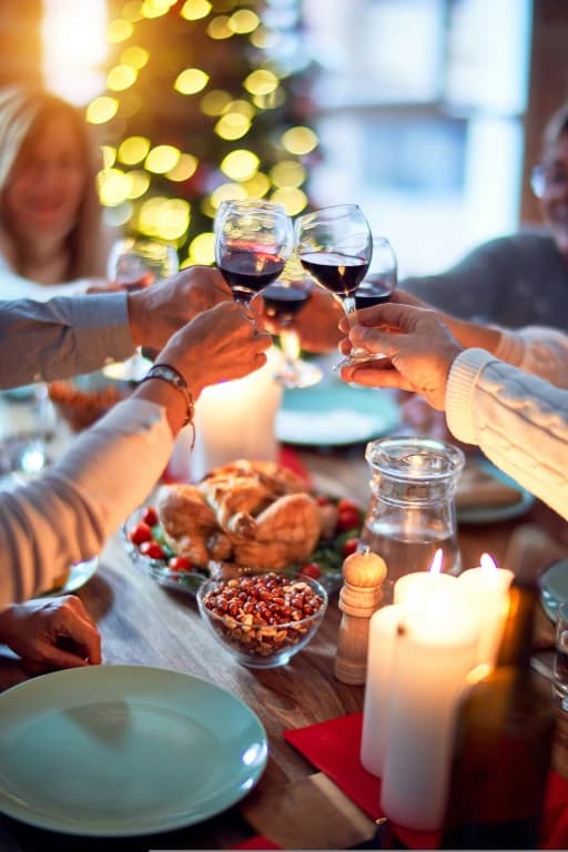 Guests raising their glasses around a festive holiday table