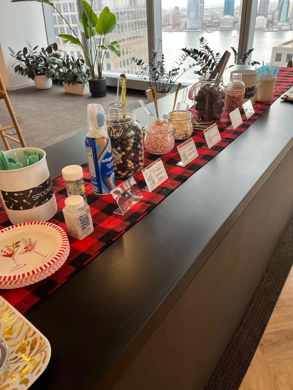 A hot chocolate topping station with marshmallows, sprinkles, and whipped cream