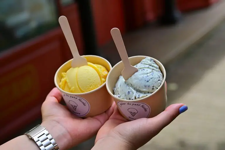 Two cups of ice cream with wooden spoons