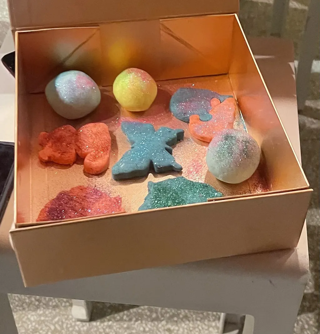 Box of completed bath bombs in various colors and shapes