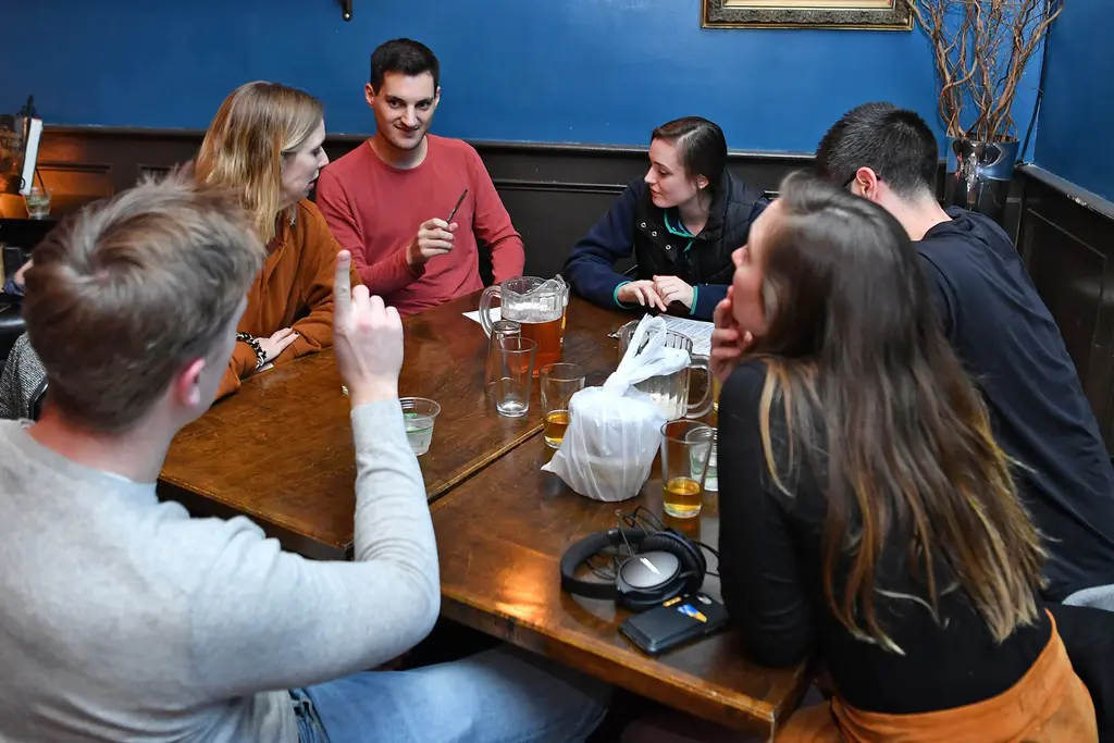 Group engaging in a lively trivia conversation around a table