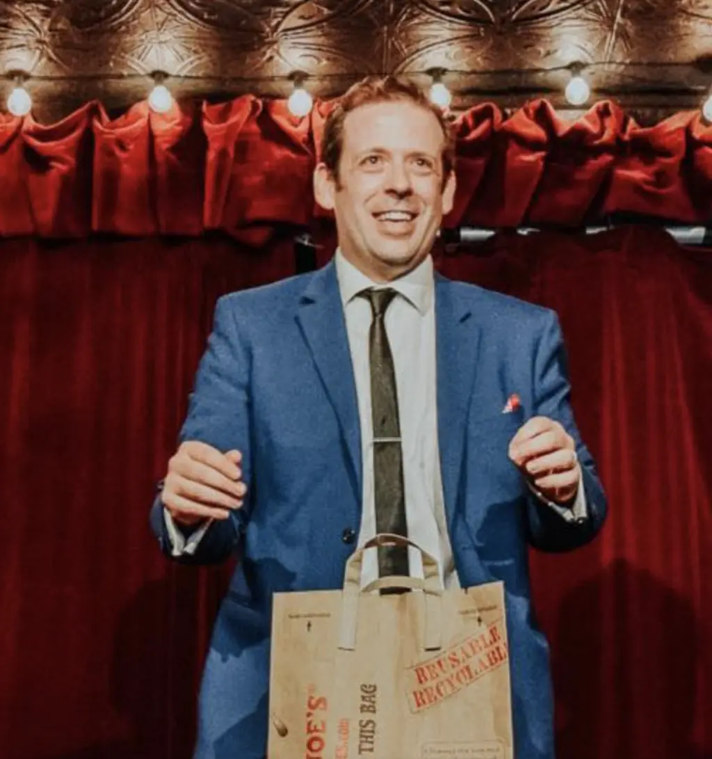 a man standing in front of a crowd on stage doing magic