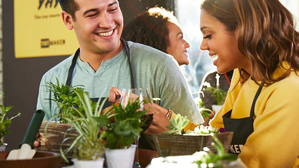 two people laughing and planting succulants in pots