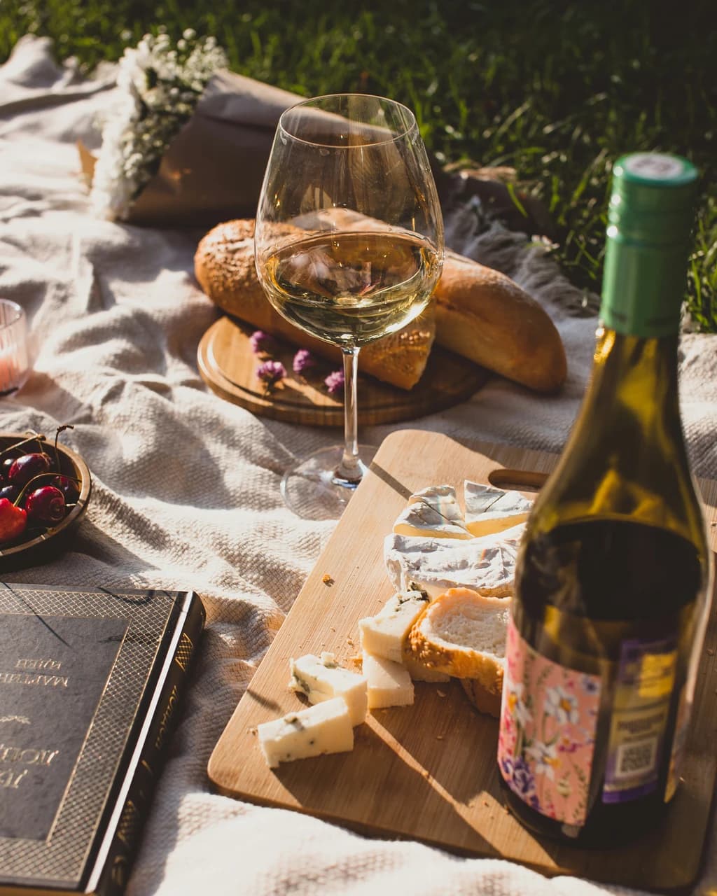 white wine, bread, and cheese on a cutting board