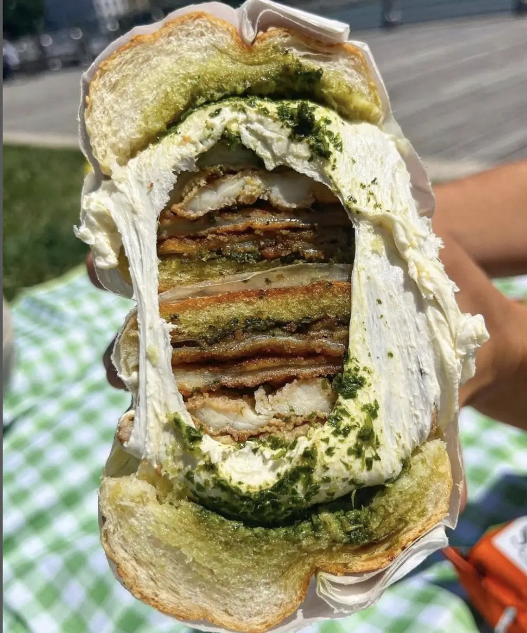 a large sandwich opened in the middle with melted cheese
