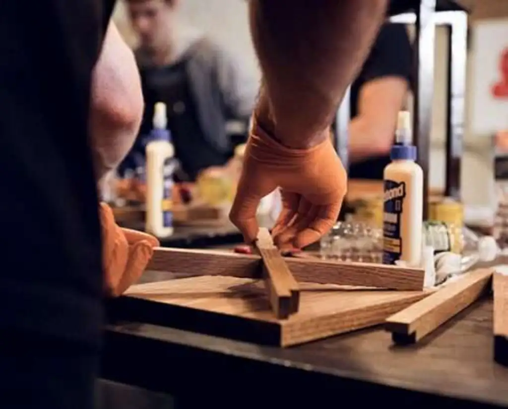 a wooden cask of beer, and someone pouring a beer from it into a glass